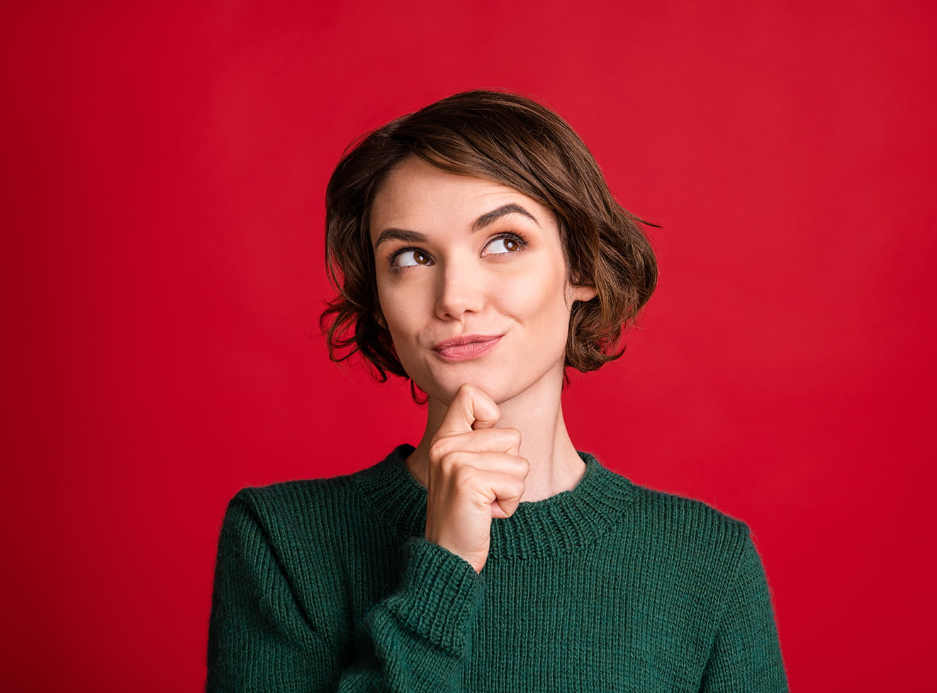 Woman holding her chin with a smirk 