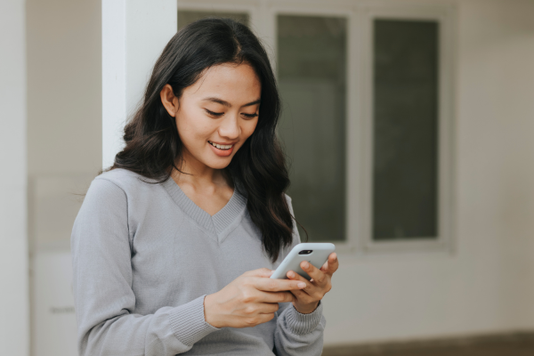 Young woman looking at her phone and smiling