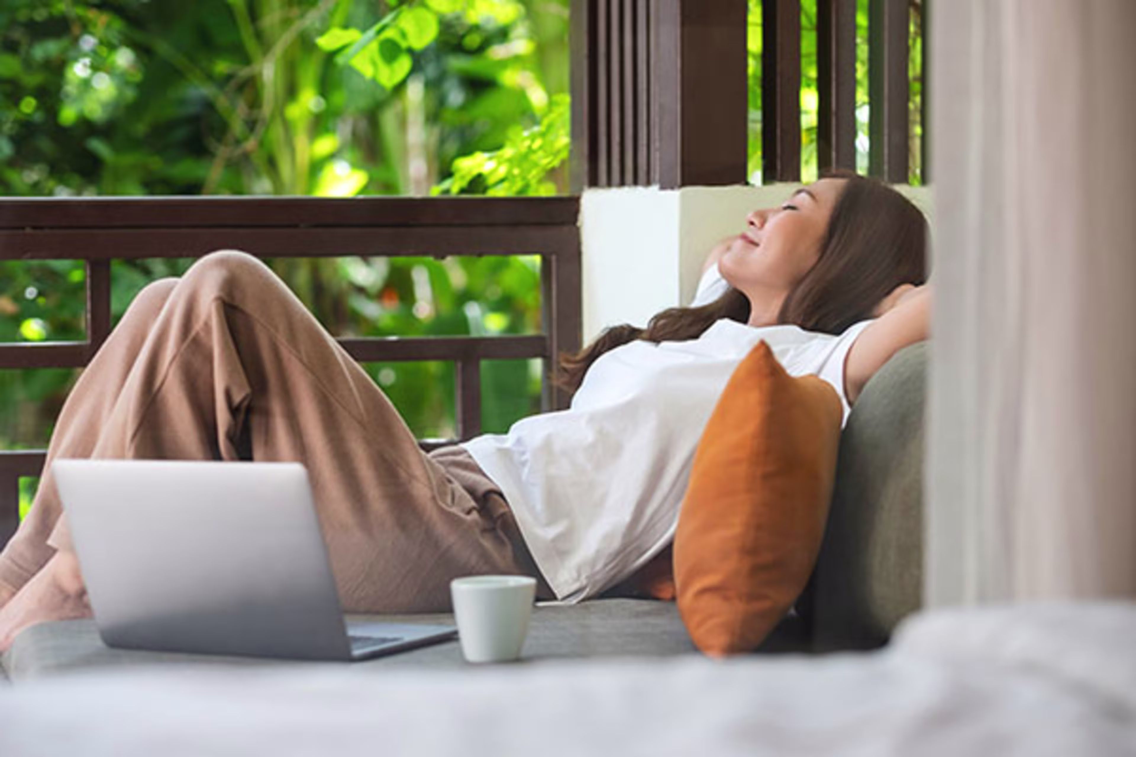 Woman relaxing on a balcony, enjoying the view of city life—perfectly illustrating the benefits of Condo Mortgage Loans for those seeking their ideal condo or apartment home.