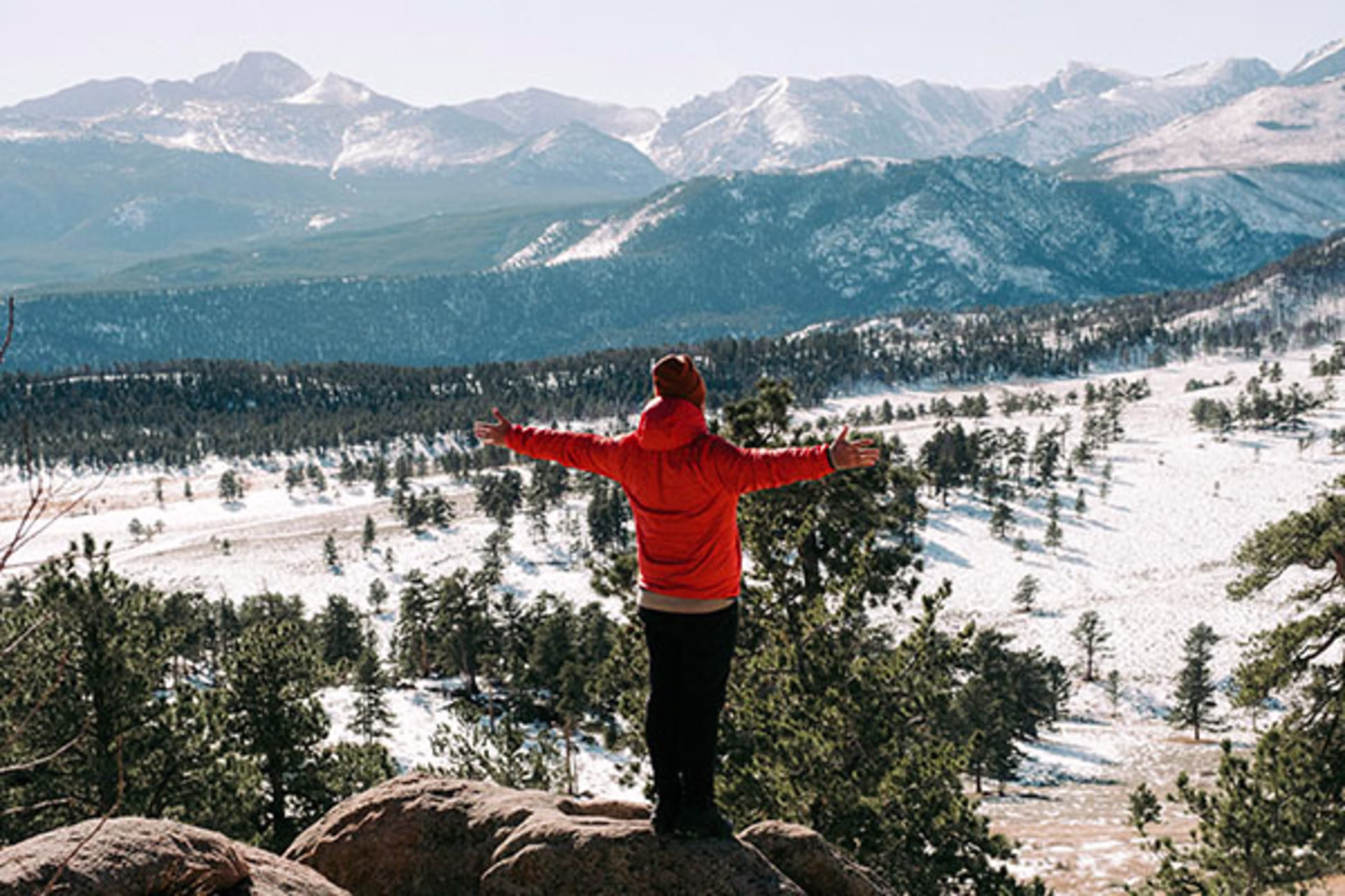 Man overlooking a vast mountain range, symbolizing big dreams and big homes—Westerra offers jumbo loans to help members reach new heights in Colorado real estate.