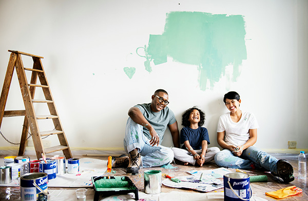 Family sitting together in front of painted wall renovating their house with a Westerra Credit Union Home Equity Line of Credit Loan