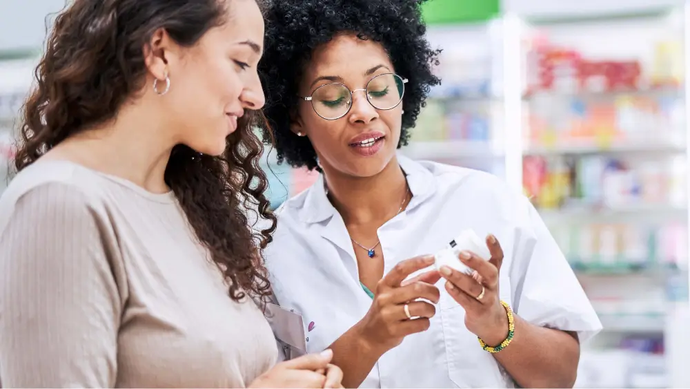 Pharmacist showing a medication bottle to a customer