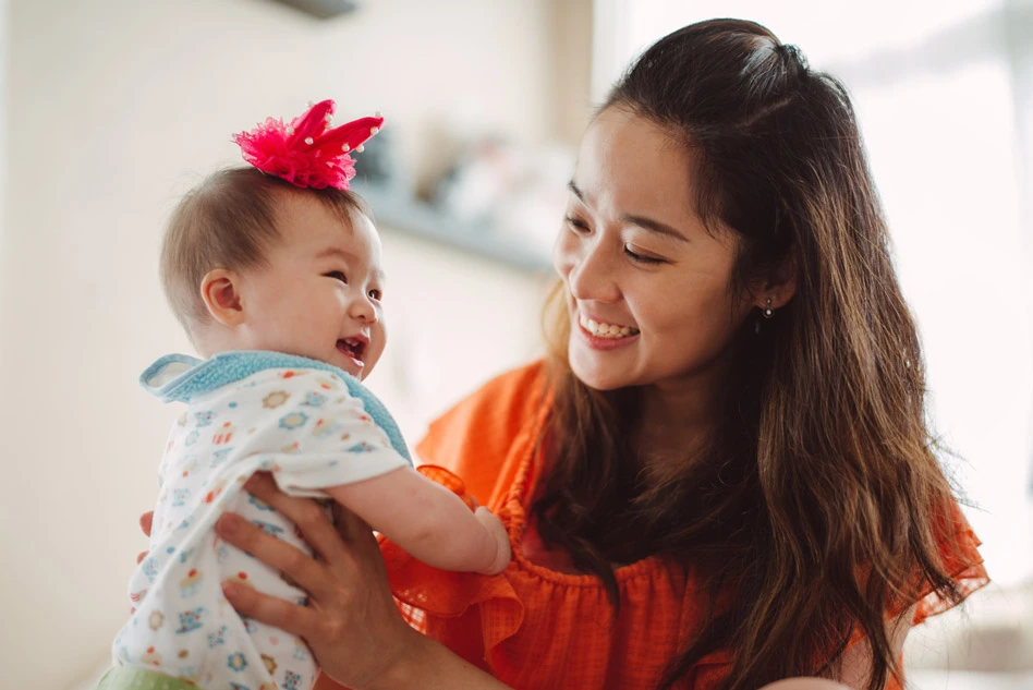 Woman smiling holding a baby