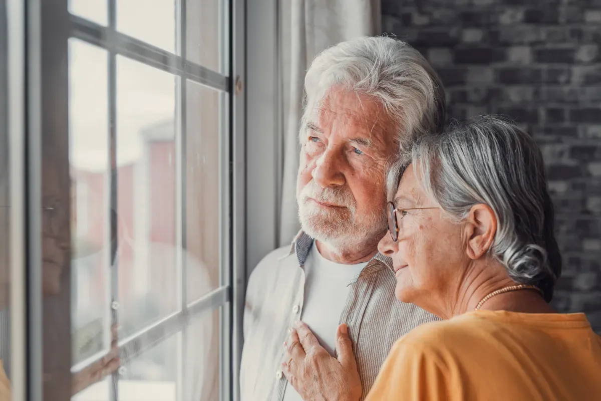Negatief zelfbeeld - oudere man en vrouw kijken samen serieus naar buiten
