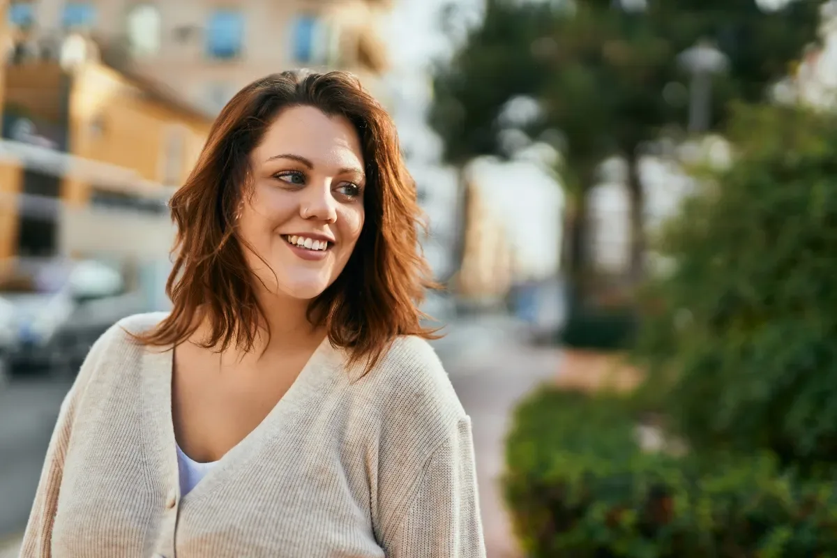 Positieve emotie - vrouw kijkt vrolijk weg in stad