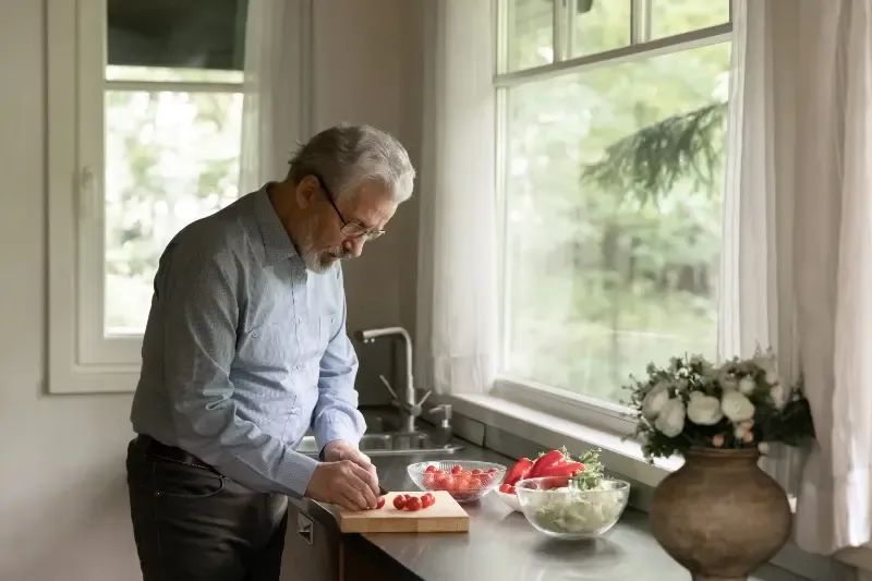 Waarom is een gezonde lunch belangrijk? - oude man maakt maaltijd in keuken