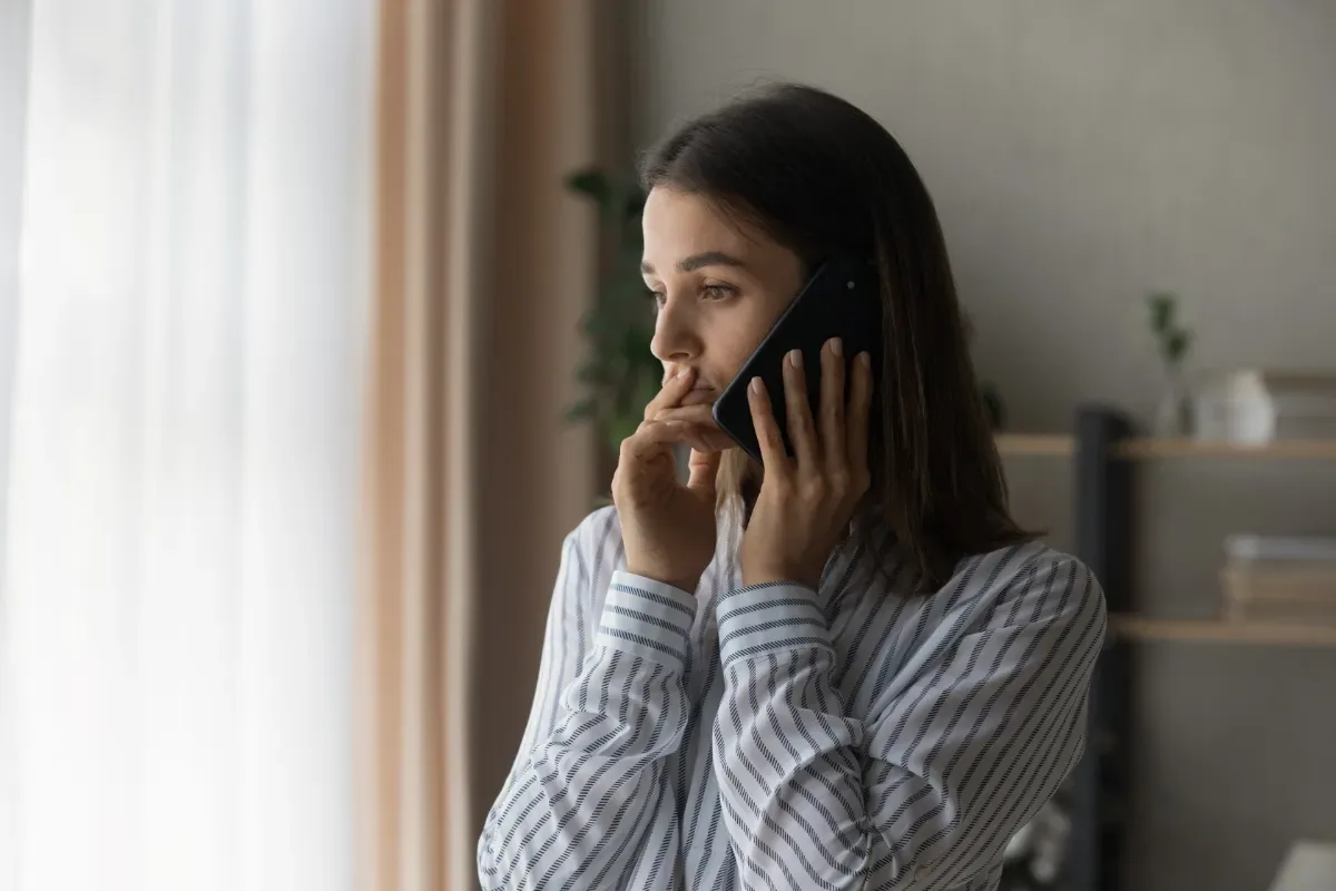 Belastingdienst schulden en incasso’s: voorkom escalatie - bellende vrouw kijkt serieus met hand bij gezicht