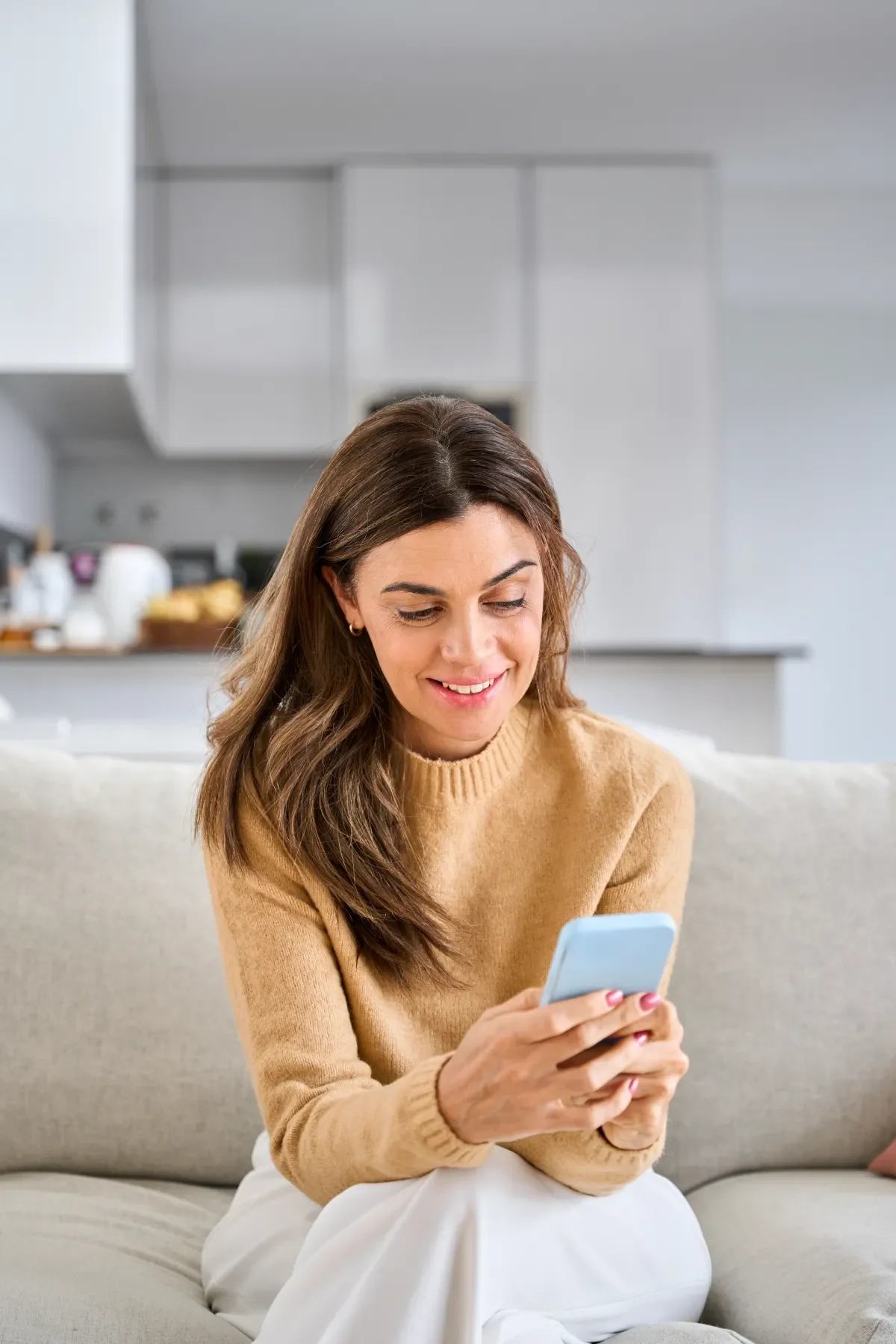 Positieve emotie - vrouw op bankstel met telefoon
