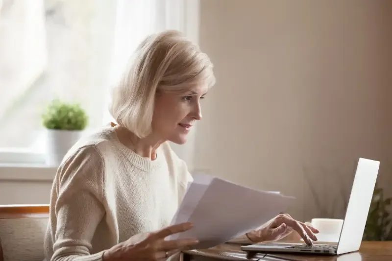 Professionele hulp: waarom is het zo belangrijk? - vrouw met papierwerk achter laptop