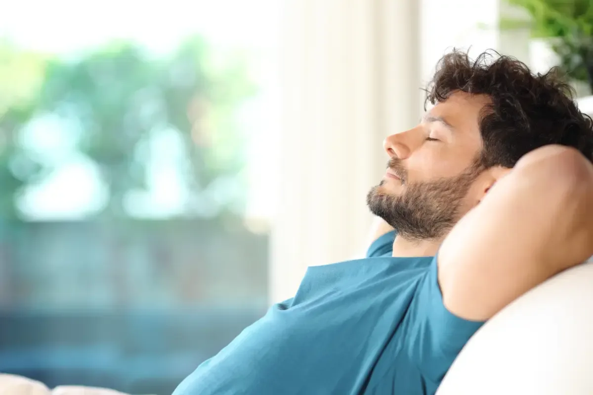 Wat is stress en hoe herken je het? - jonge man ontspant met handen achter hoofd