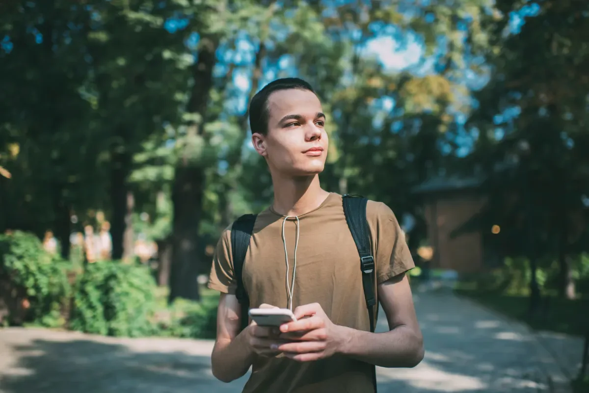 Neutrale emotie - jongen in natuur kijkt weg van telefoon