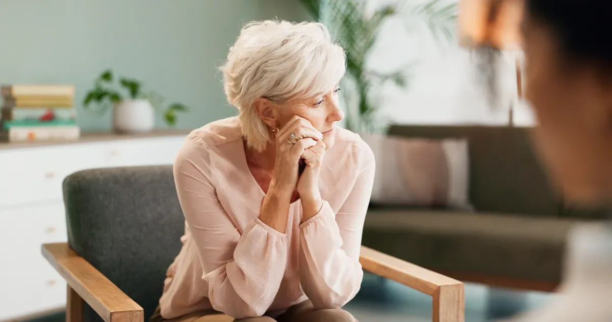 Negatieve emotie - vrouw op stoel kijkt weg tijdens gesprek