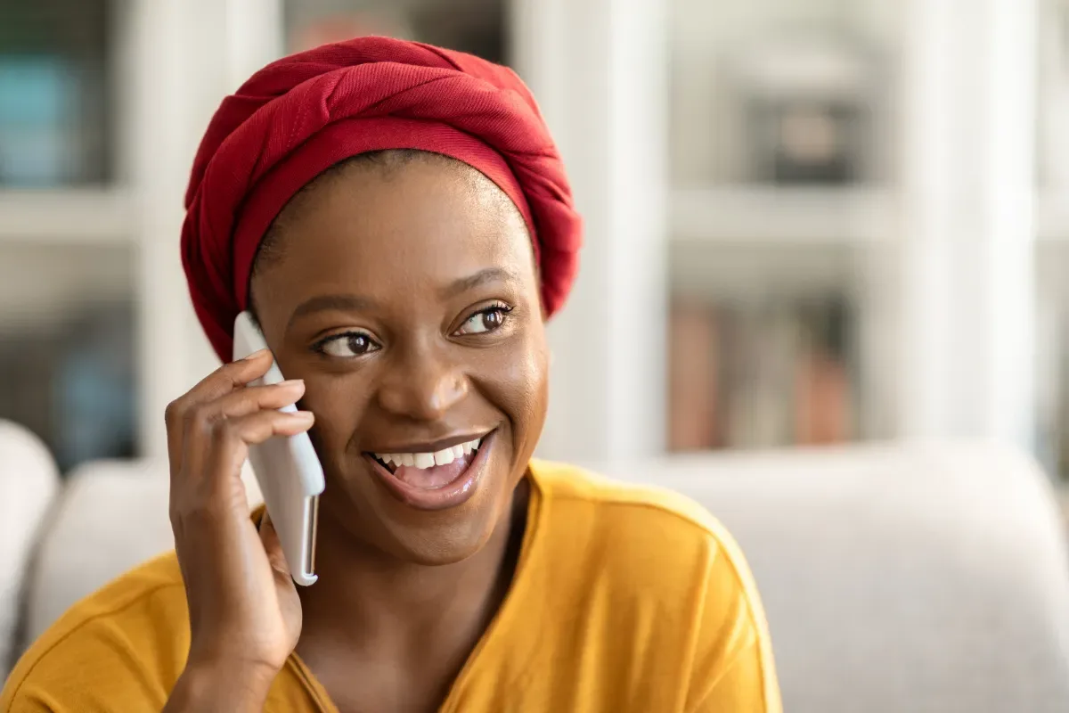 Positieve emotie - blije vrouw is aan het bellen in woonkamer
