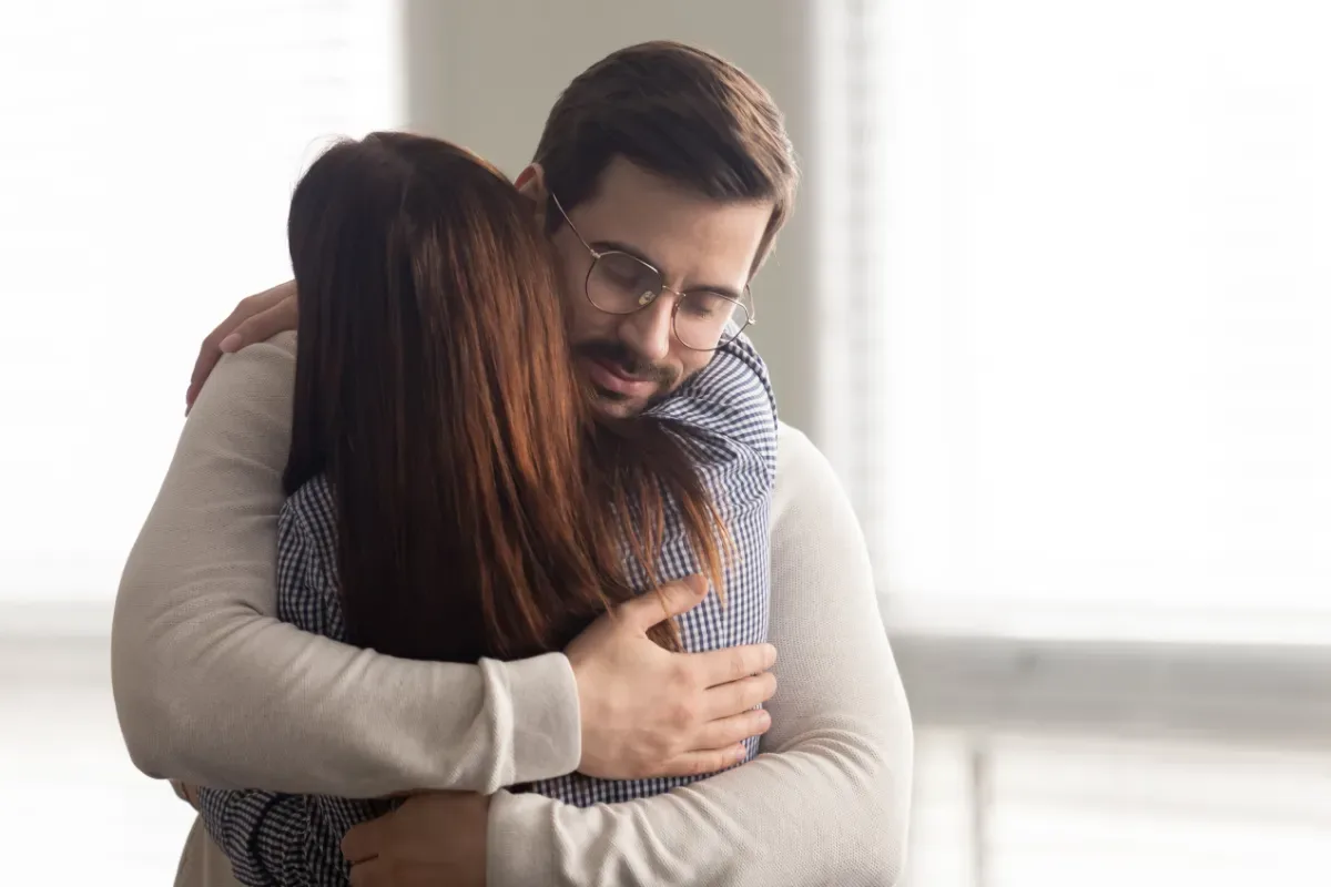 Verdrietig zijn uit zich ook lichamelijk - man en vrouw knuffelen serieus