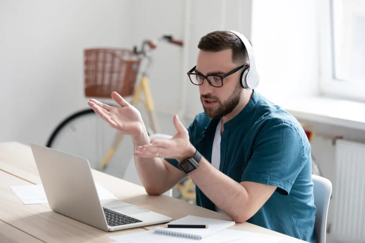 Consultatie - man met koptelefoon zit pratend achter laptop