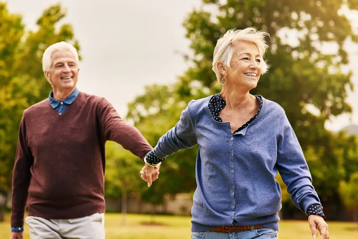 Positieve emotie - man en vrouw hand in hand lopen speels door natuur