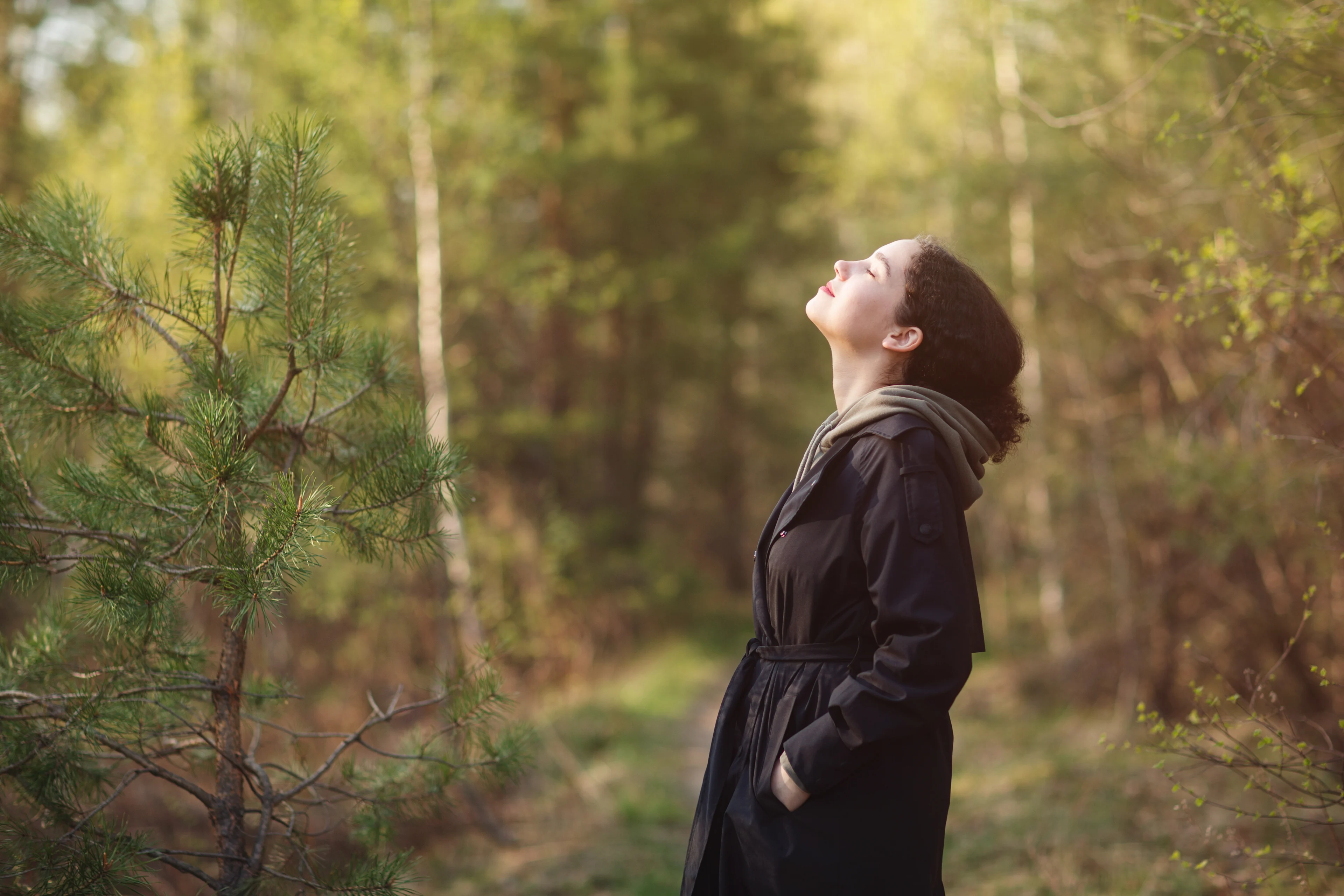 PTSS of een normale stressreactie? - Vrouw staat in de bossen en geniet van frisse lucht