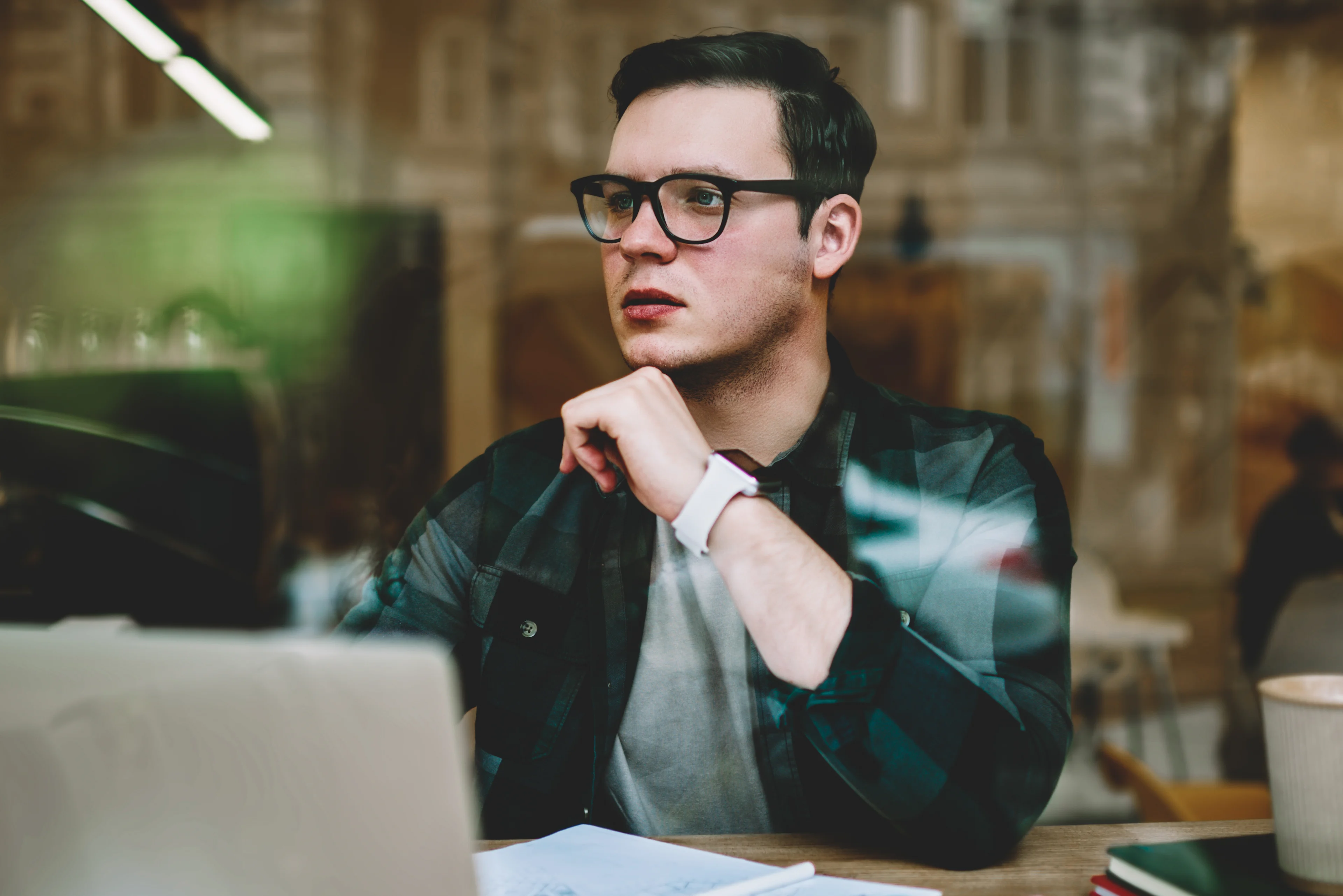 Wat als je wilt stoppen? - jonge man kijkt bedenkelijk over zijn laptop