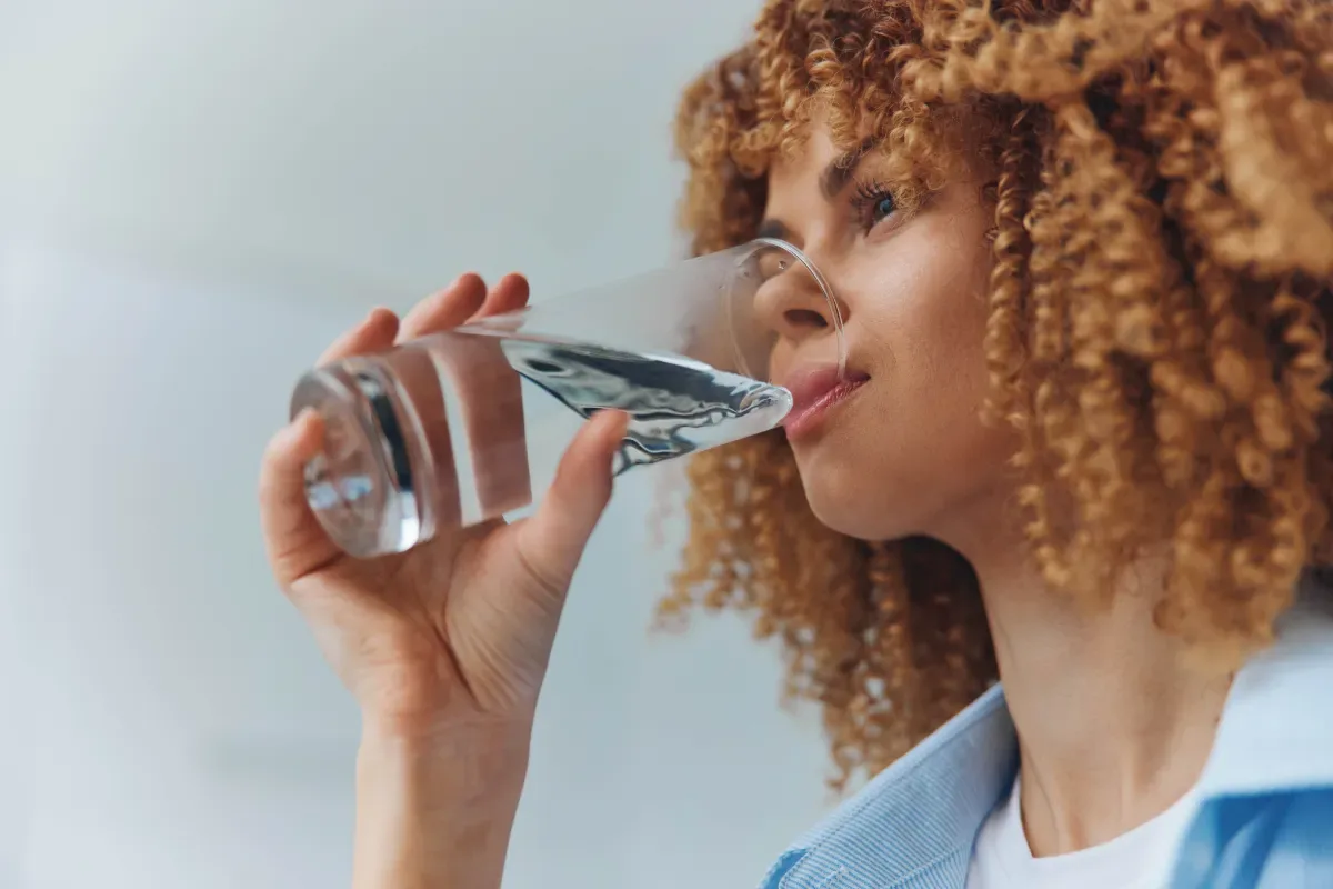 Stress en afvallen: hoe zit dat? - vrouw drinkt glas water