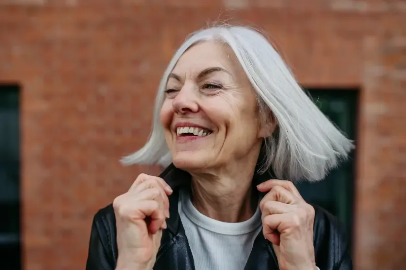 Blij met jezelf - oudere vrouw lacht vrolijk met speels haar