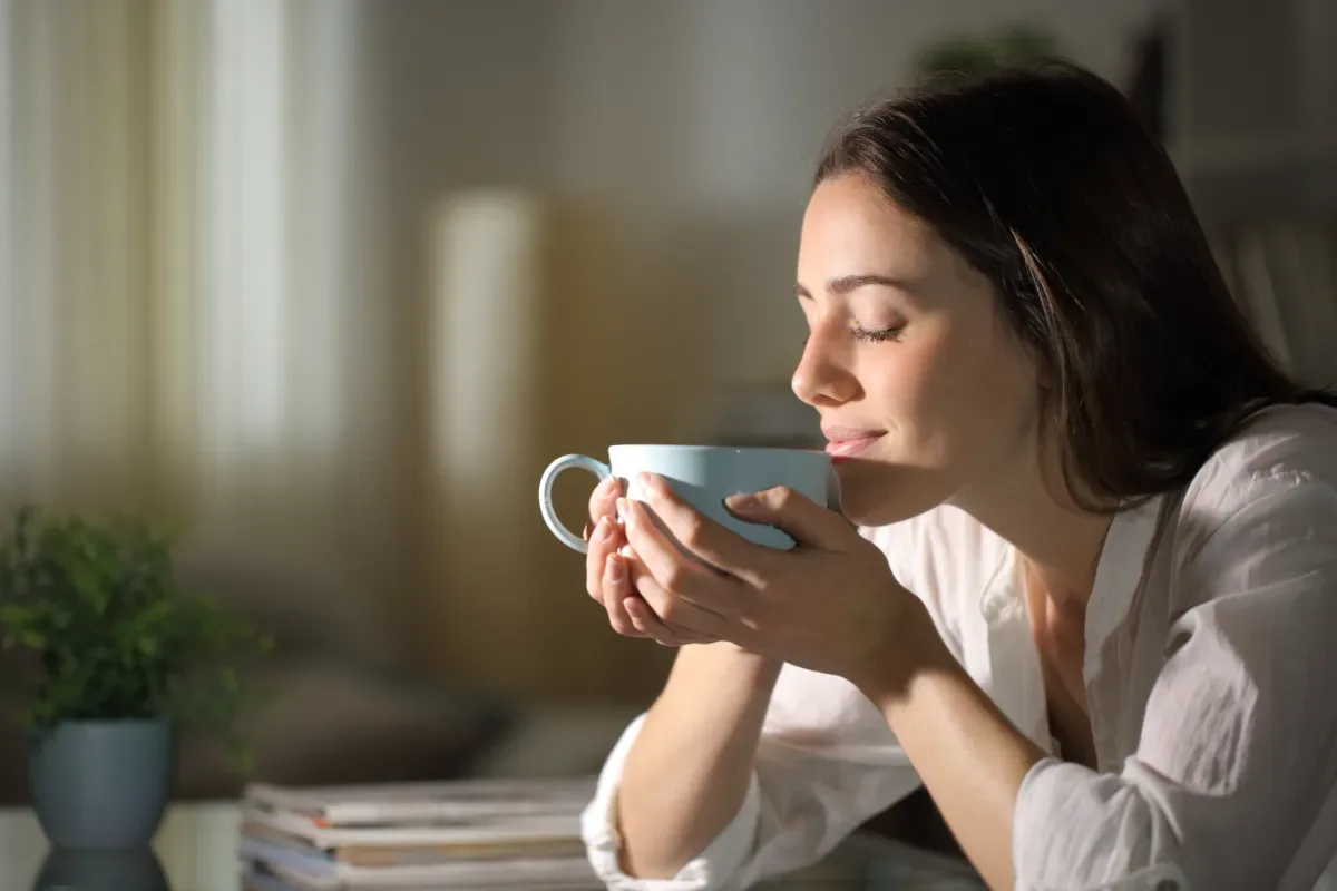 Ontspannen - vrouw met ogen dicht van kopje thee