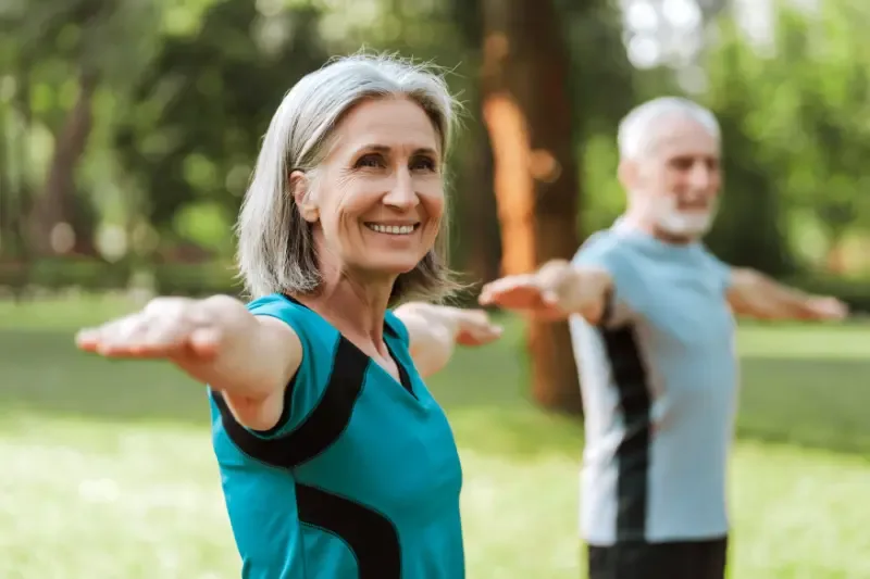 Gezondheid en welzijn: een wisselwerking - vrouw en man doen balans oefening in de natuur