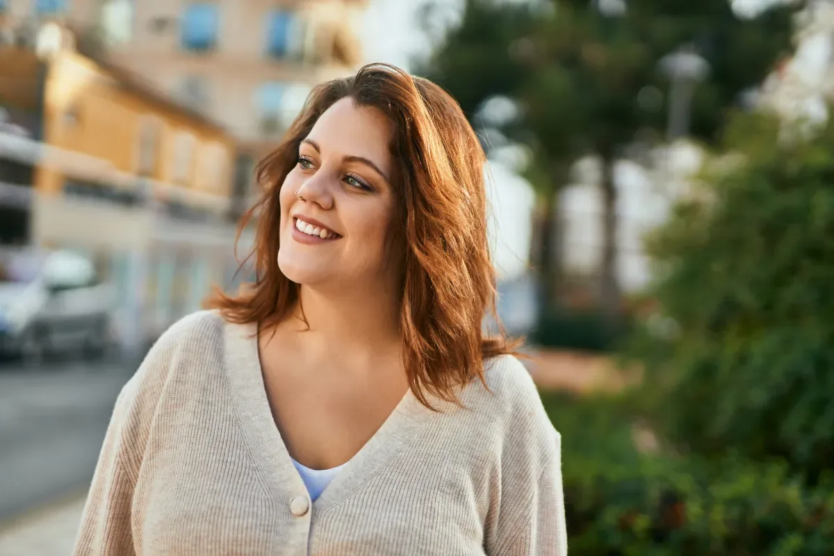 Positieve emotie - vrolijke vrouw in stad met zonlicht
