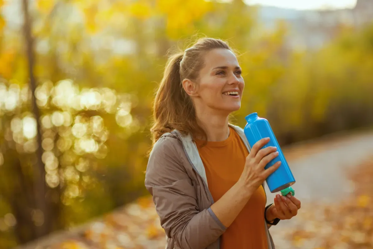 Stoppen met alcohol - vrouw met waterfles in natuur