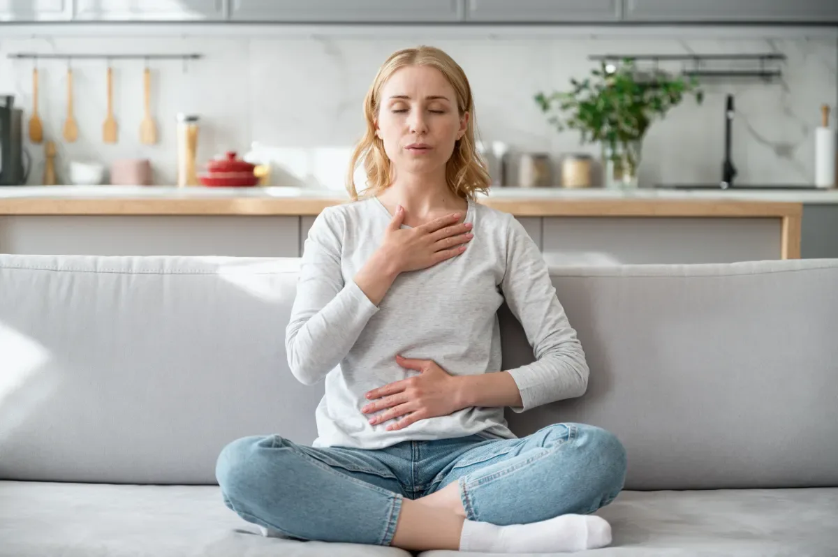 Mindful leven - vrouw doet ademhalingsoefening op bankstel