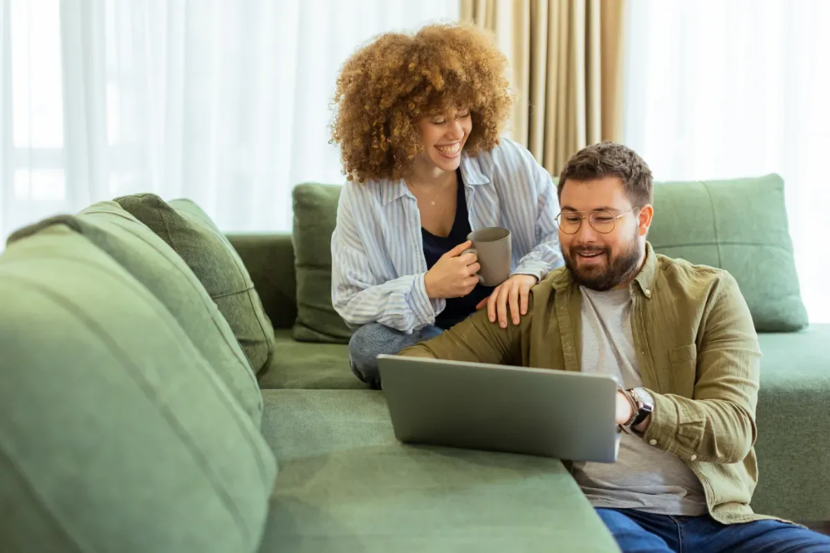 Positieve emotie - man en vrouw kijken samen naar laptop