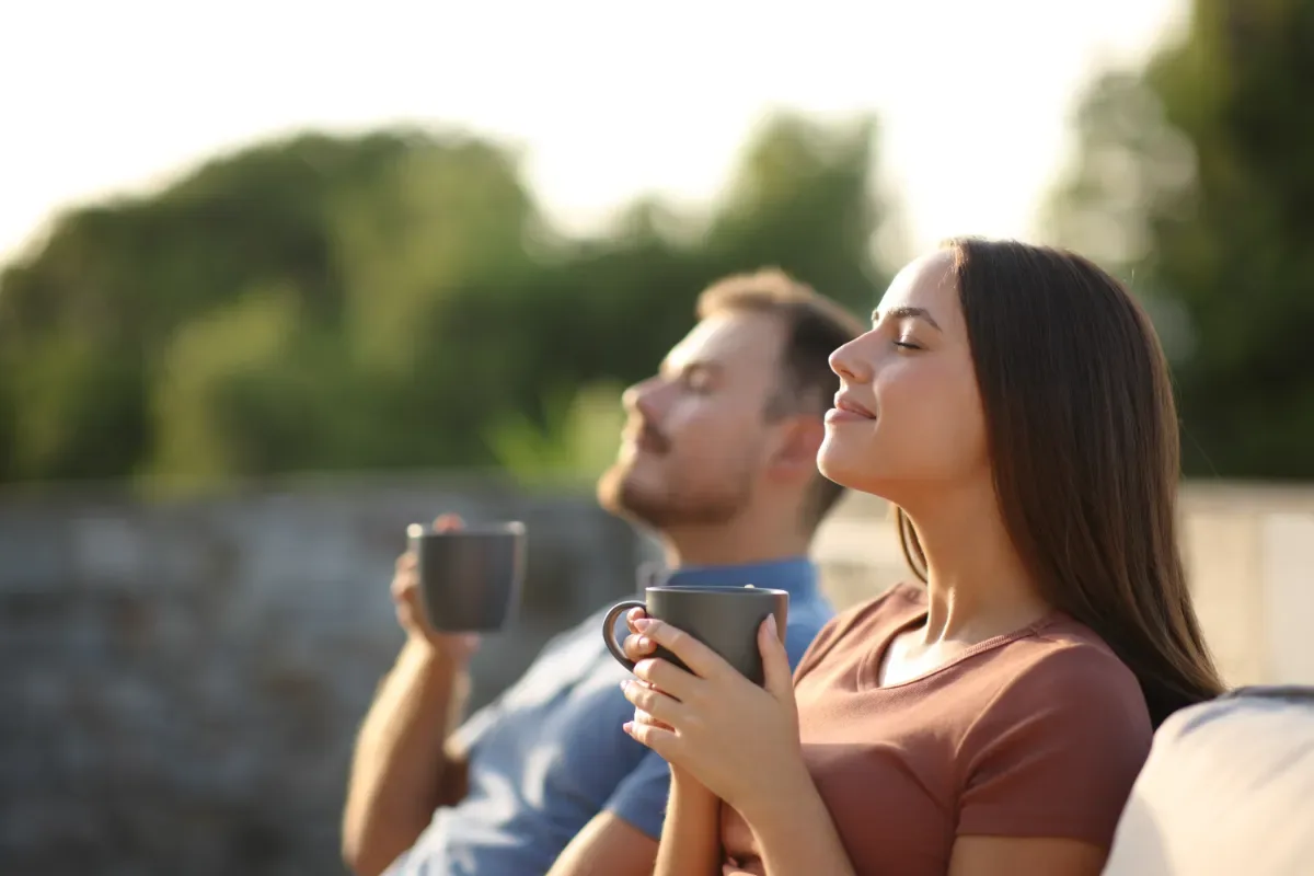 Positieve emotie - man en vrouw genieten van zon en kopje koffie