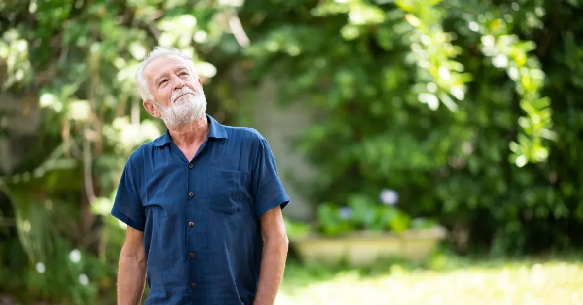 Positieve emotie - oude man kijkt tevreden tijdens natuur wandeling