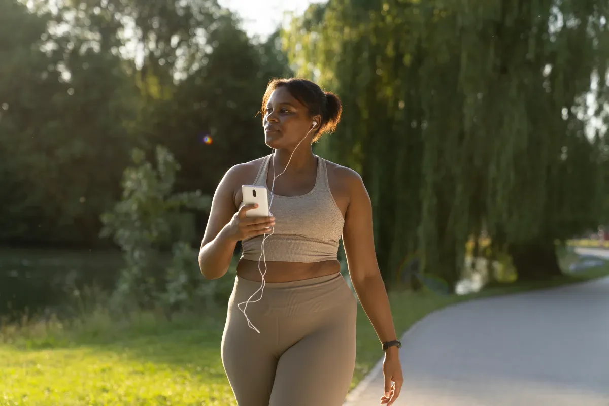 Neutrale emotie - sport vrouw in park met telefoon en oortjes in