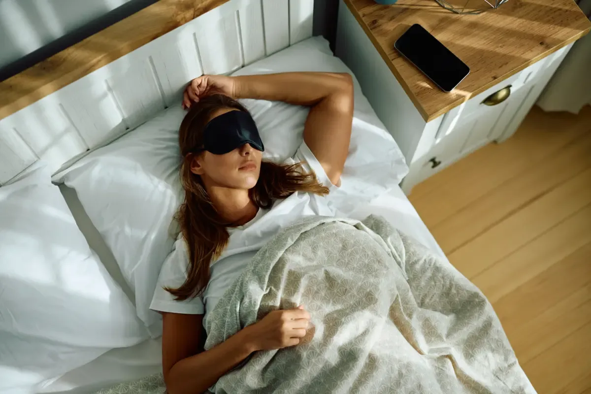 Insomnia - vrouw ligt met oogmasker op bed te slapen