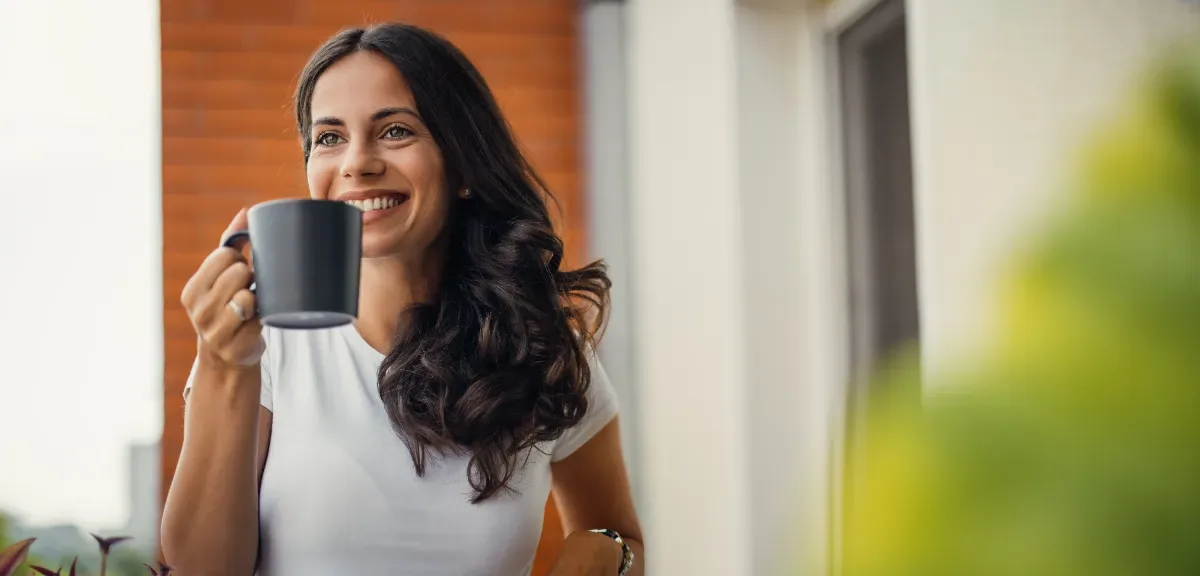 Positieve emotie - vrouw met kop koffie in hand