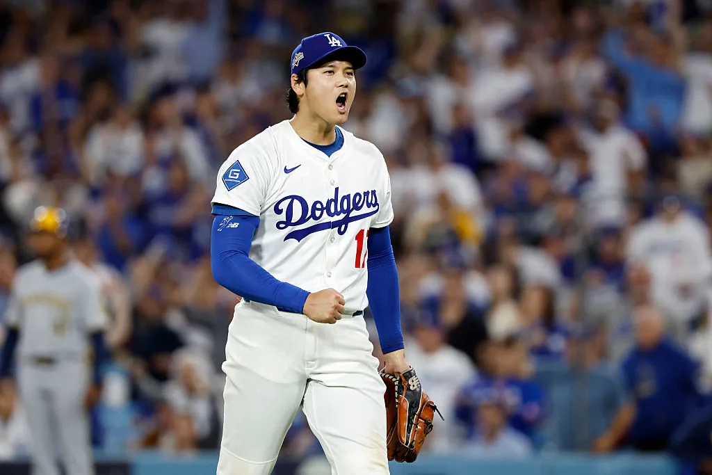 Los Angeles Dodgers pitcher and designated hitter Shohei Ohtani is screaming and pumping his fist in excitement.