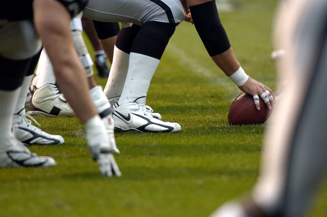 View of offensive linemen lined up and ready to snap the football.