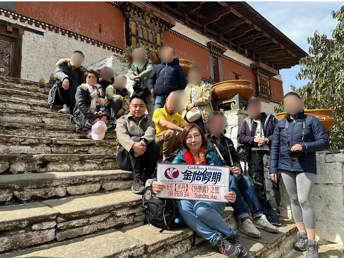 金怡假期不丹旅行團團友於帕羅宗 Paro Dzong 前合照，背景為宏偉的不丹式建築