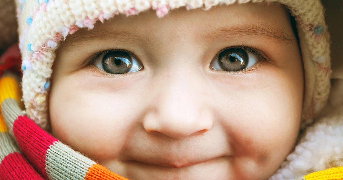 bébé portant un foulard et un chapeau
