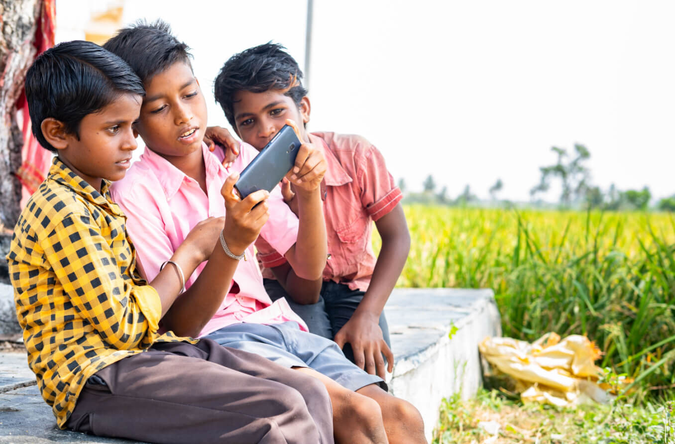 Young women in India reading on their digital devices.