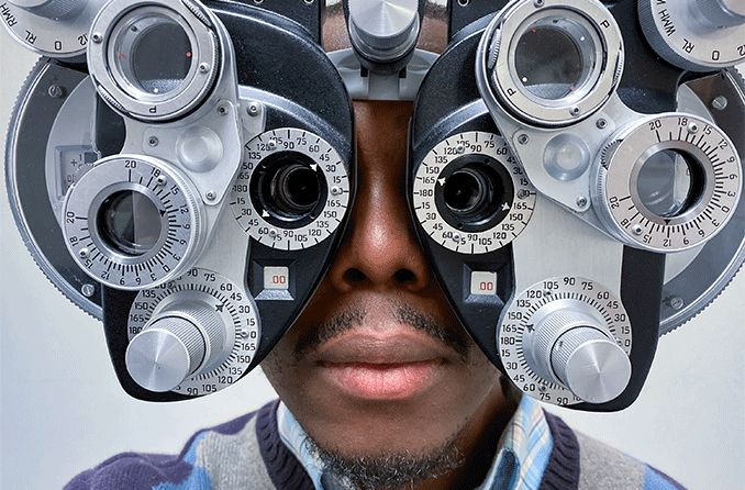man looking through a phoropter with 20/15 vision