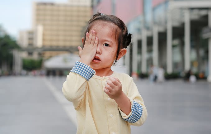 Enfant couvrant les yeux à cause de l'amblyopie