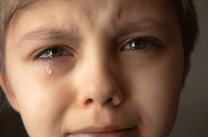 child with tears coming out of eyes