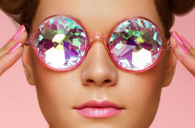 woman wearing jeweled eyeglasses on a pink background