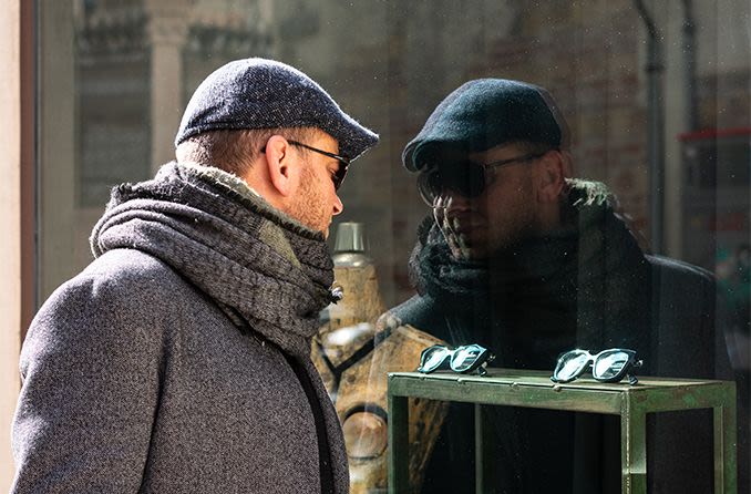 man window shopping for sunglasses in the winter