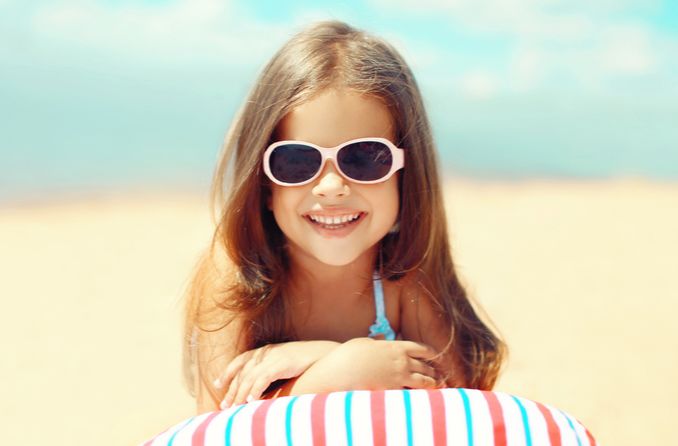 Kind schützt seine Augen durch das Tragen einer Sonnenbrille