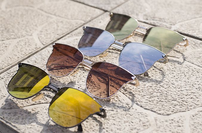 verres de lunettes de soleil de différentes couleurs sur le béton