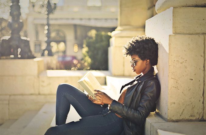 woman reading a book outside wearing reading sunglasses