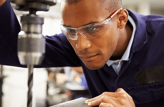 Homem utilizando lentes de policarbonato ou orgânicas para trabalhar na indústria.