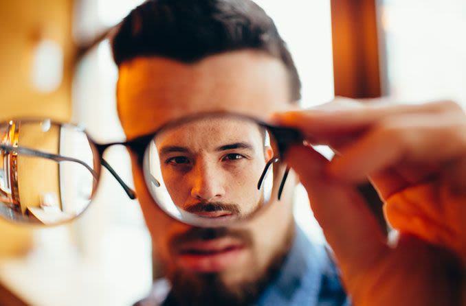 Man looking through lens of eyeglasses